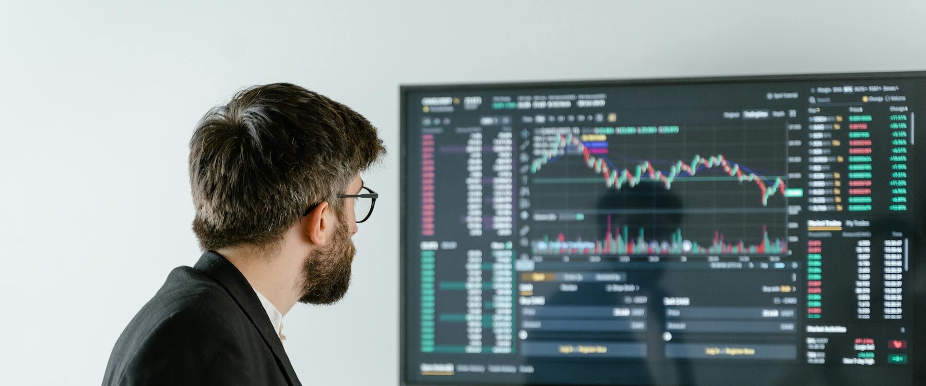 Man Observing Stock Market Data On A Screen And Holding A Tablet, Representing Financial Analysis And Trading. Man Observing Stock Market Data On A Screen And Holding A Tablet, Representing Financial Analysis And Trading.