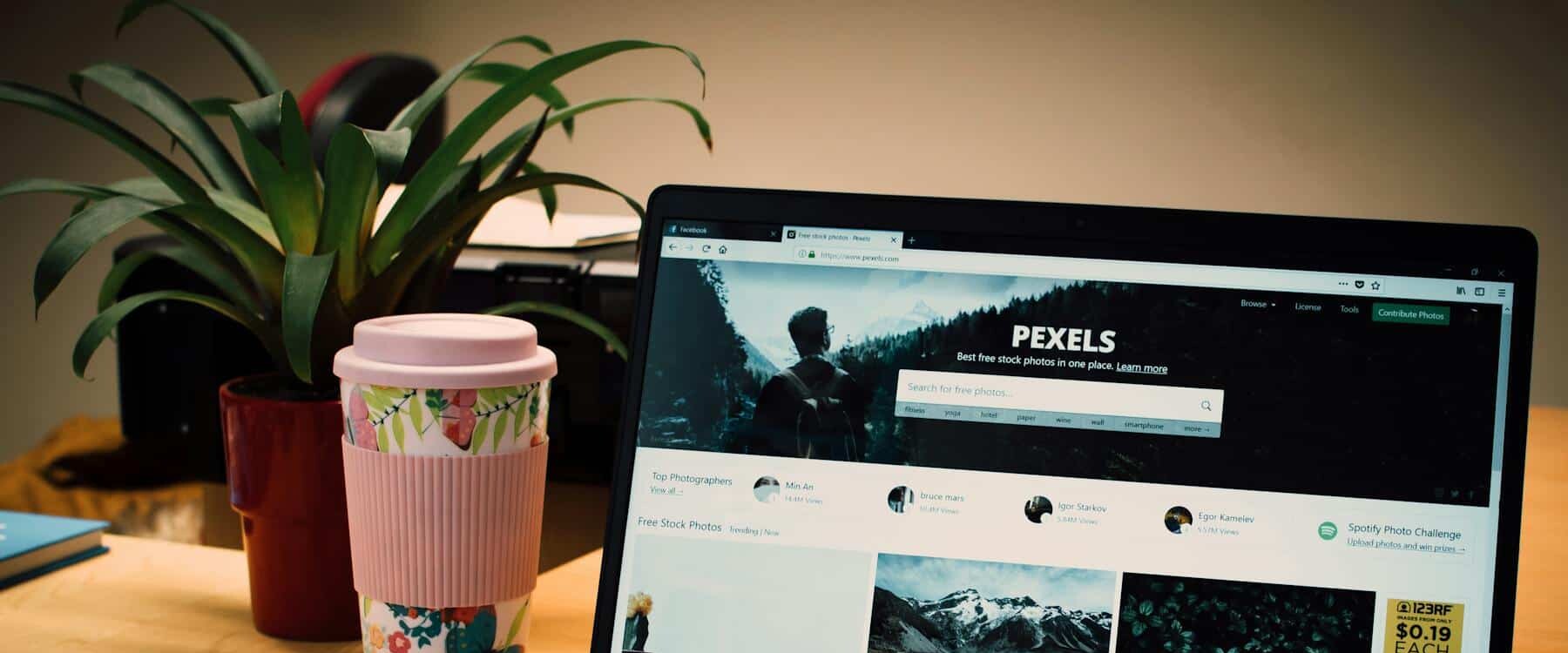 A Tidy Desk Setting With A Laptop Showing A Stock Photo Website And A Smartphone. A Tidy Desk Setting With A Laptop Showing A Stock Photo Website And A Smartphone.